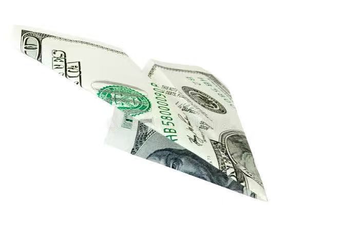 Paper airplane folded from a 100 US dollar bill